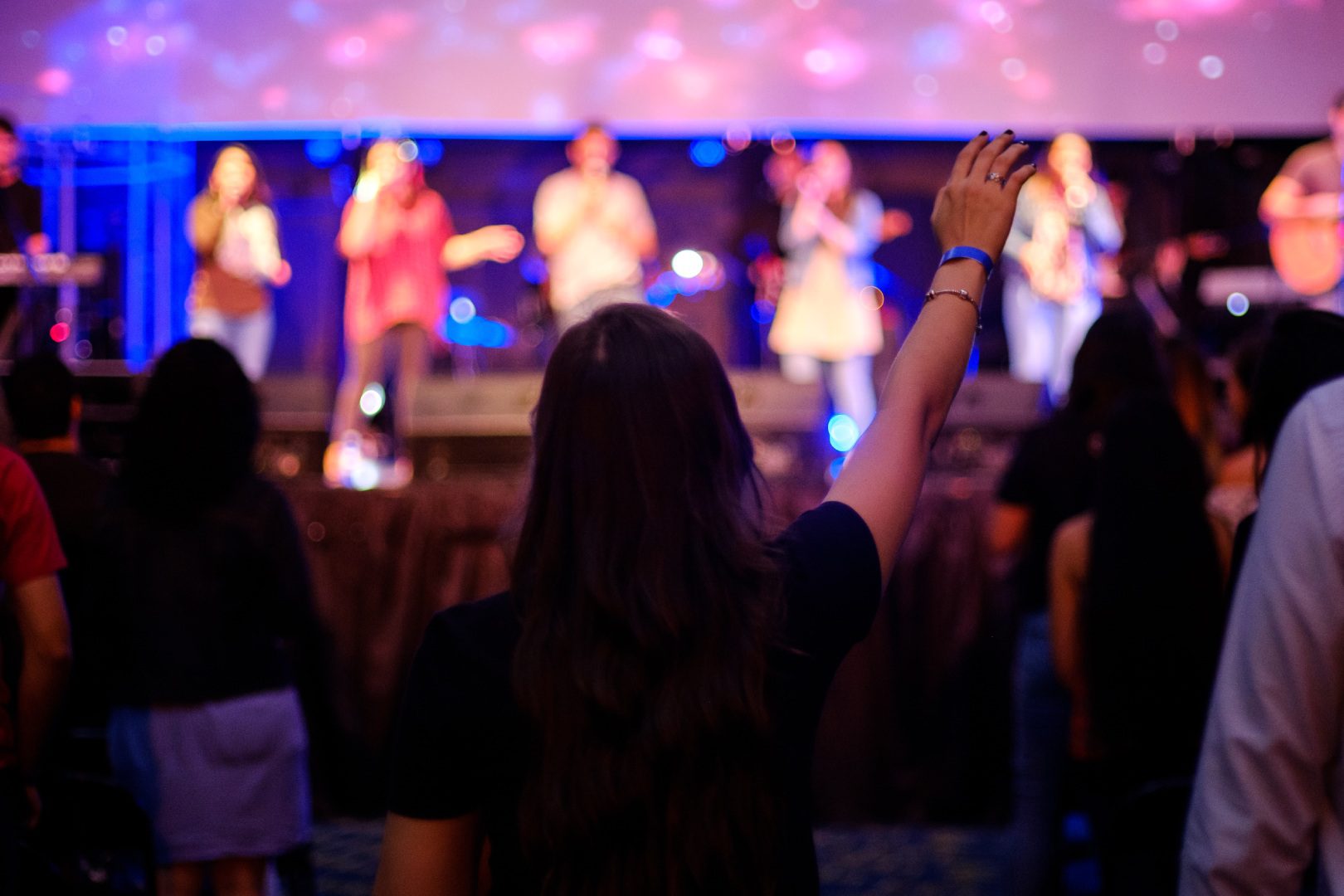 A woman raising her hand in front of a group.